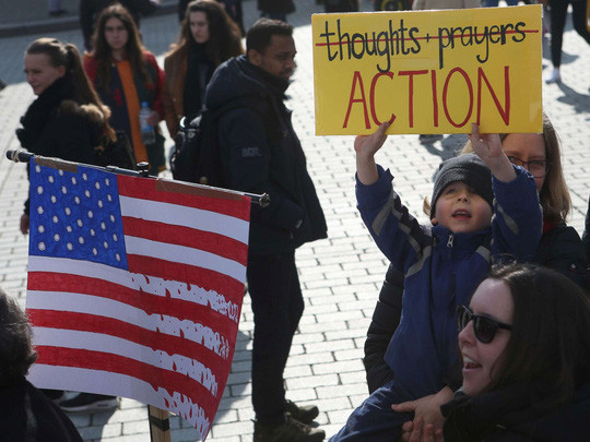 Một cậu bé giương cao biểu ngữ yêu cầu chính phủ Mỹ "hành động" ở thủ đô Berlin - Đức, hôm 24-3. Ảnh: ABC News
