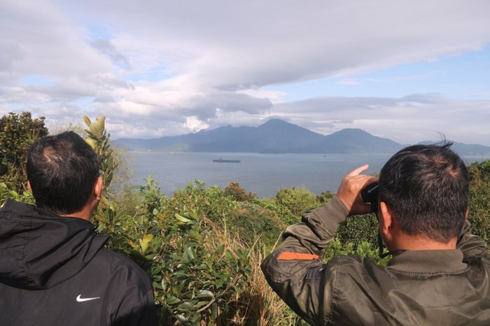 Chiếc ống nhòm được chia sẽ, chuyền tay nhiều người có mặt để quan sát. Từ vị trí này, với chiếc ống nhòm, người dân có thể tận thấy từng máy bay trên tàu sân bay USS Carl Vinson khá rõ nét. Ảnh Nguyễn Thành.