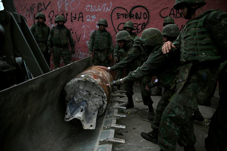 Hình ảnh binh sĩ Brazil phá bỏ các rào chắn do các băng đảng ma túy ở Rio de Janeiro dựng lên để kiểm soát các khu phố, thậm chí là ngăn chặn cảnh sát tiến vào bên trong các khu vực trên. Ảnh: Reuters.