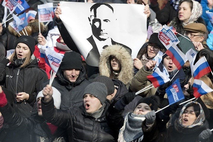 Những người ủng hộ Putin giơ một tấm chân dung đen trắng của ông. Ảnh: AP.