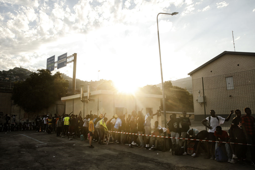 Người tị nạn xếp hàng chờ lấy thức ăn ở Ventimiglia. Ảnh: AFP.