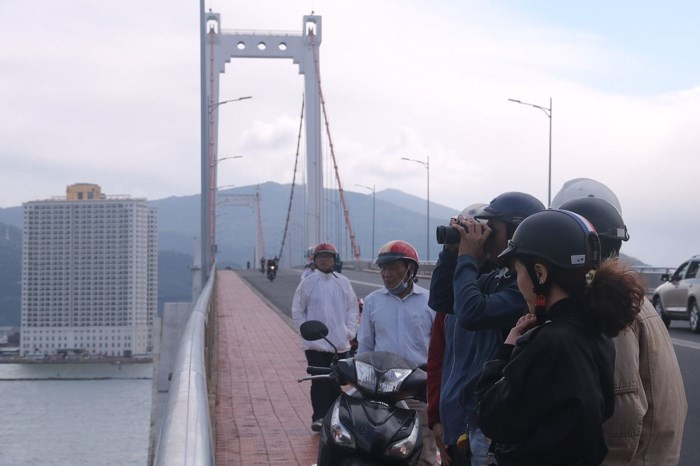 Trong khi đó, tại cầu Thuận Phước bắc qua sông Hàn, từ sáng sớm nay (9/3) nhiều người dân với ống nhòm đã có mặt tại đây để quan sát tàu sân bay đang neo đậu tại vịnh Đà Nẵng. Ảnh Nguyễn Thành