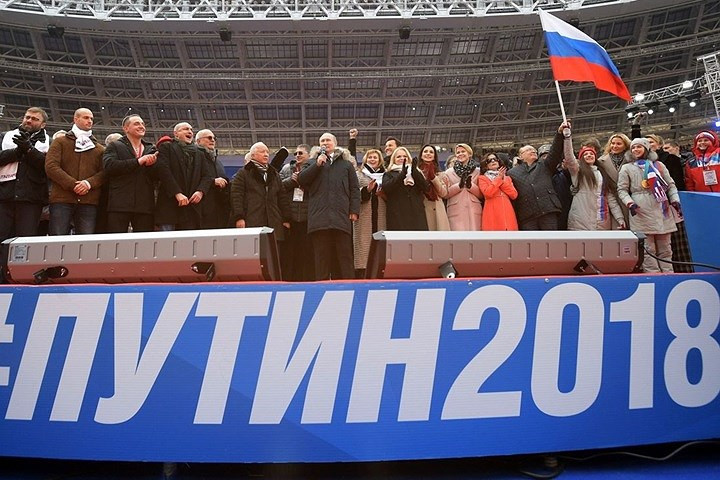 Tổng thống Putin đứng giữa các vị khách ở trên bục nằm giữa sân vận động Luzhniki. Ảnh: Sputnik.