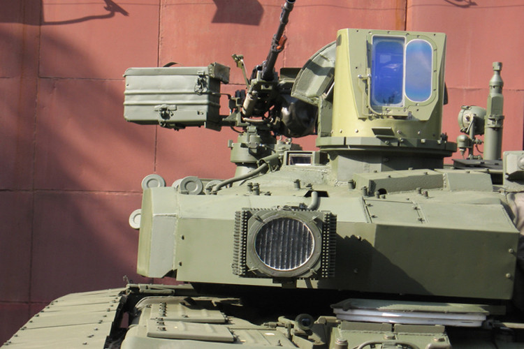 Tuy nhiên, thực tế là vậy, vấn đề của T-84 Oplot-T là nó được trang bị hệ thống điều khiển hỏa lực quá đồ sộ. “Mắt thần” săn tìm mục tiêu của T-84 Oplot-T to nhưng “cột đình” lắp trên nóc tháp pháo. Trong ảnh, “dấu đỏ” là một phần quan trọng của hệ thống điều khiển hỏa lực trên Oplot-T. Nếu mất nó, Oplot-T sẽ mất hoàn toàn khả năng săn tìm mục tiêu và tấn công tiêu diệt. Nguồn ảnh: Thai Defence