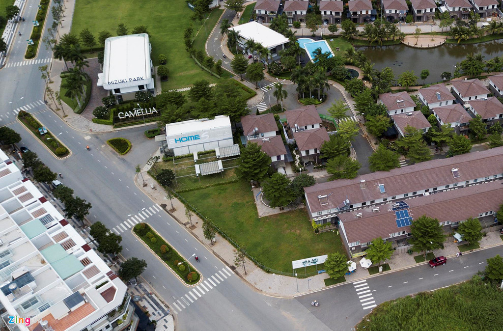 Phía mặt tiền khu biệt thự với nhiều mảng cỏ xanh cũng được che chắn bằng hàng rào sắt.