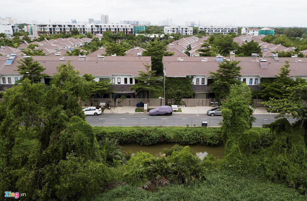 Ngăn cách khu biệt thự và phần đất bỏ hoang là những hàng rào sắt.