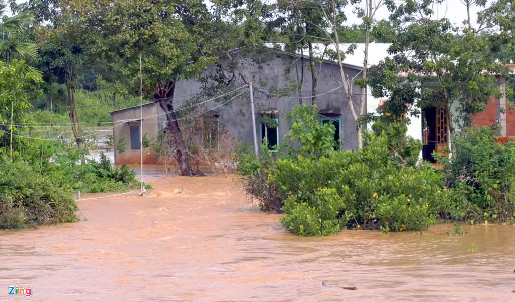 Nước lũ bắt đầu dâng lên gây ngập đường từ lúc 6h. "Nước lên rất nhanh, chảy về cuồn cuộn. Tôi chỉ kịp ôm con chạy ra khỏi nhà", chị Huyền (ở phường Tân Đồng, TP Đồng Xoài) nói.