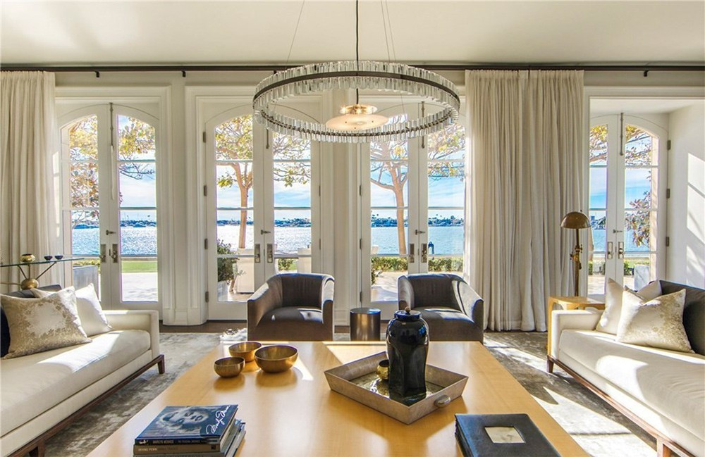 Phòng khách rộng rãi, thoáng đãng, tràn ngập ánh sáng tự nhiên, mang tông màu trắng nhẹ nhàng. Những cách cửa kiểu Pháp mở ra hiên nhà đón nắng.