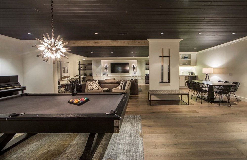 Phòng giải trí với khu vực ăn uống, một sân khấu nhỏ để chơi nhạc, và một bàn billiard sang trọng, kiểu cách.