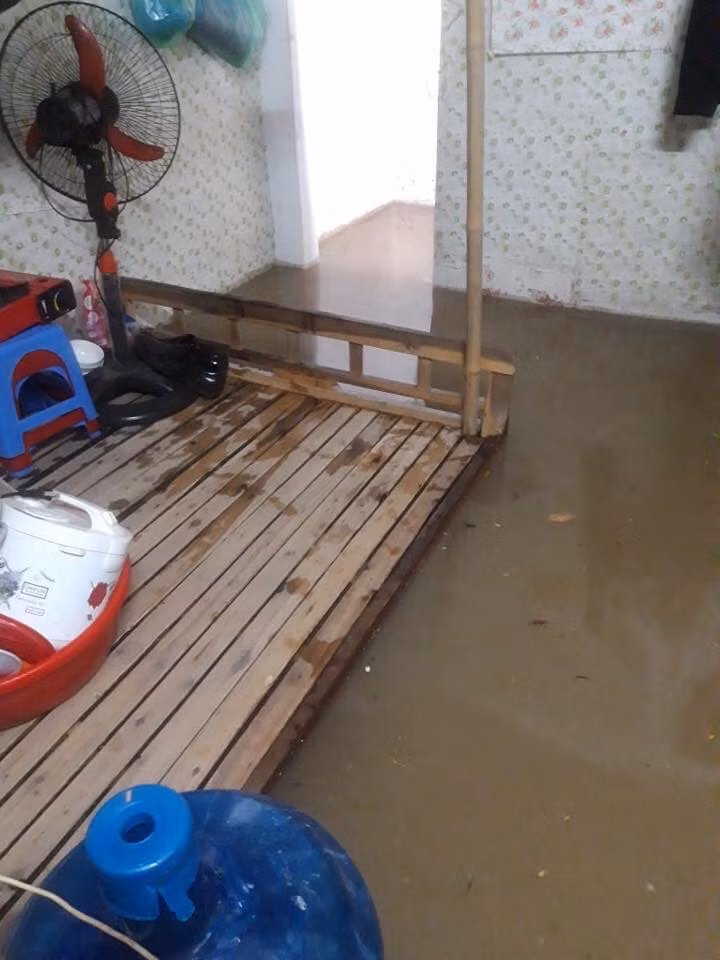Người dân phải sơ tán đồ sinh hoạt lên giường khi nước ngập vào nhà.