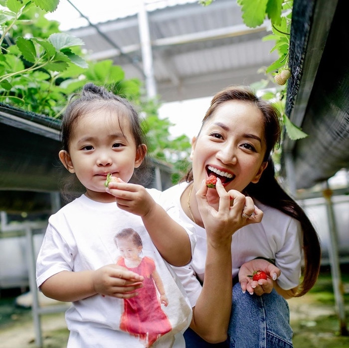 Khánh Thi cùng con gái nhỏ hái dâu vui vẻ ngoài vườn.