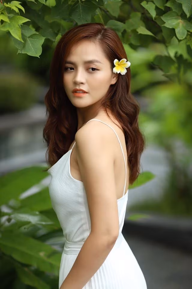 Thu Quỳnh đẹp tinh khôi với váy trắng, tóc cài hoa.