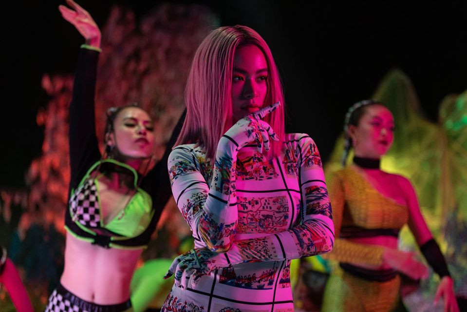 Tuy nhiên, Hoàng Thùy Linh nhanh chóng được "minh oan". Hoàng Ku - stylist của Hoàng Thùy Linh trong MV thanh minh: “Bộ trang phục này không phải áo dài cách tân như một số bạn hay các page đang bàn tán. Đây là bộ váy xẻ hai bên hông, liền bao tay, dùng họa tiết tranh Hàng Trống để in lên toàn bộ thân váy được đặt riêng cho Linh".