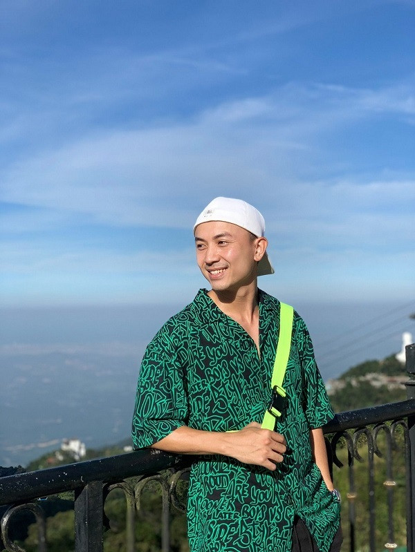 Diễn viên Anh Vũ diện áo sơ mi rộng kết hợp túi đeo chéo và nón lưỡi trai cá tính.