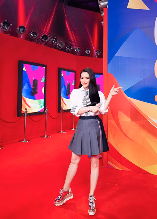 Cô diện áo sơ mi hàng hiệu kết hợp váy nữ tính.