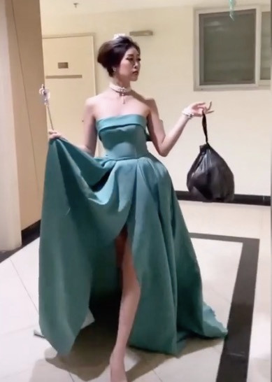 Cô phải đi tìm khá lâu mới thấy thùng rác để hoàn thành video. Phía dưới, người hâm mộ khen Khánh Vân hài hước, dễ thương khi bắt trend " mặc dạ hội đi vứt rác".