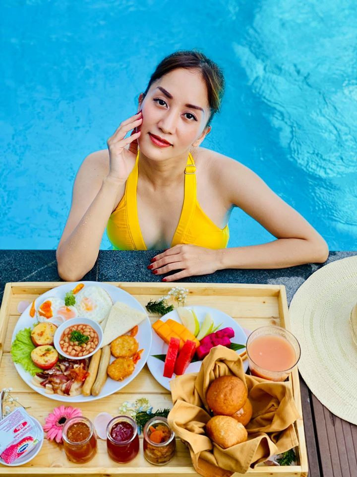 Khánh Thi ăn sáng sang chảnh ở bể bơi. Cô viết: "Yêu và được yêu là một bản nhạc nghe mãi không chán".