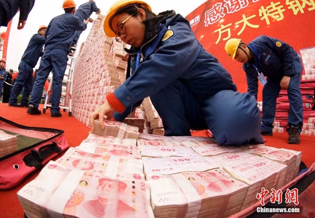 Các cọc tiền được xếp từ những tờ 100 tệ, khiến nhiều nhân viên thực sự choáng ngợp. Có người còn đùa rằng không biết họ sẽ tiêu gì để hết số tiền được thưởng.