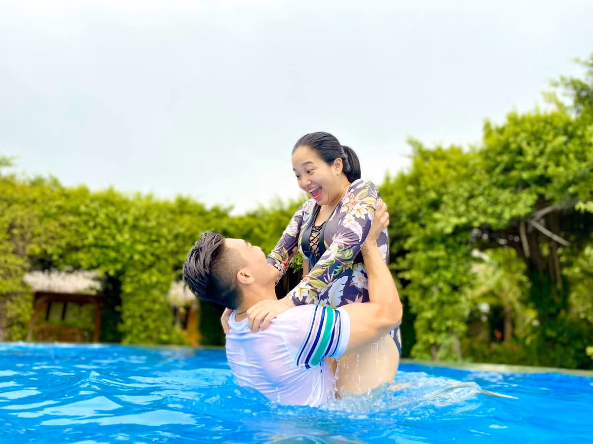 Nghệ sĩ xiếc Quốc Cơ cùng bà xã - MC Hồng Phượng khoe khoảnh khắc hạnh phúc vui đùa dưới bể bơi. "Lâu lâu cho đôi tình nhân lên sóng. Chụp được vài tấm rồi quay qua bế con ngay dù là tình nhân nhưng không quên nhiệm vụ", bà xã anh viết.