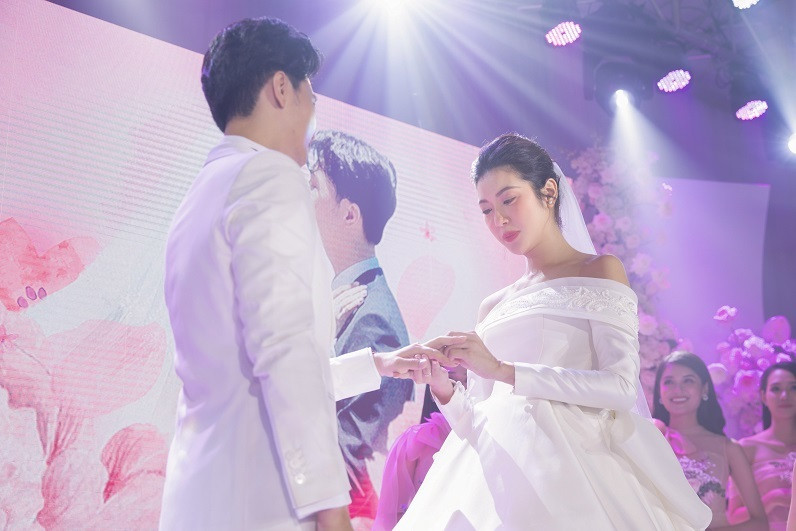 Á hậu và ông xã thực hiện nghi thức trao nhẫn cưới. Cả 2 sau đó trao nhau nụ hôn nồng nàn trước sự chứng kiến của gia đình, bạn bè có mặt.