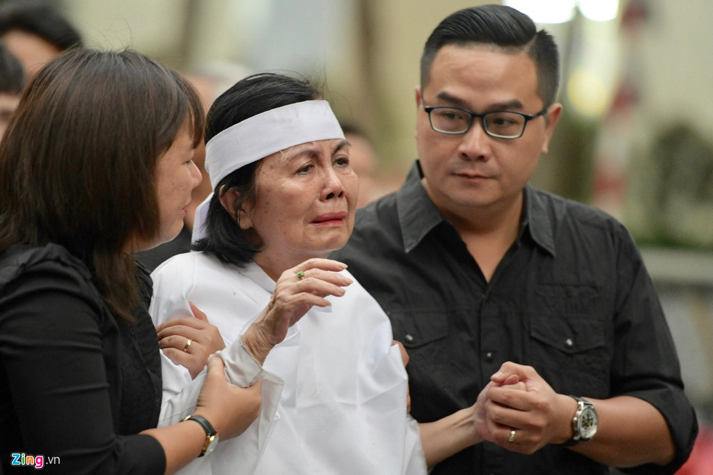 Bà Bích Trâm đi không vững, phải có người dìu. Vợ của cố nghệ sĩ khóc nức nở, gần như kiệt sức trước giây phút tiễn đưa chồng về nơi chín suối.