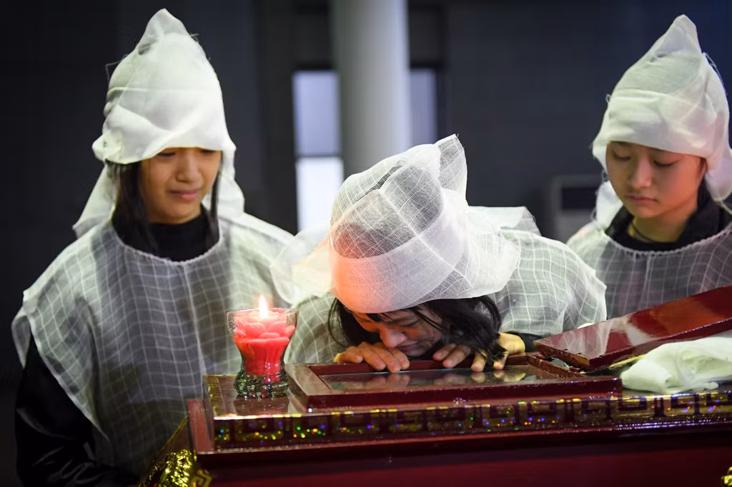 Cố nghệ sĩ Vũ Mạnh Dũng ra đi để lại người vợ và bốn con nhỏ đang tuổi ăn học. Trong ảnh, vợ của cố nghệ sĩ nhìn chồng lần cuối.