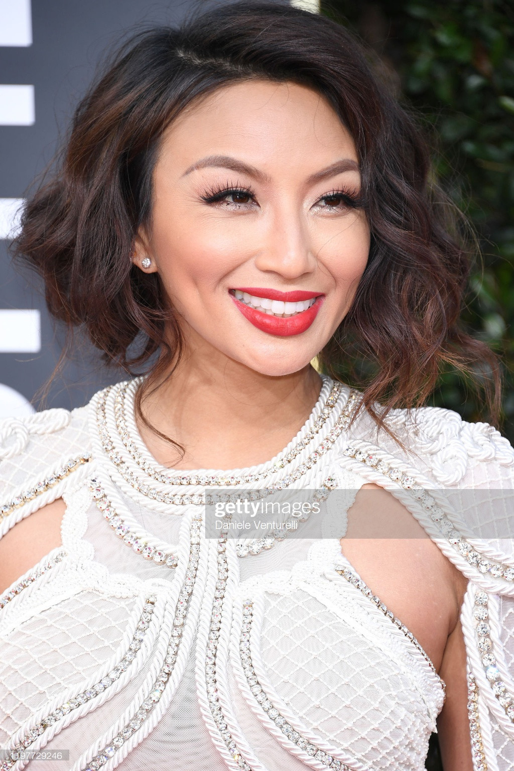 Jennie Mai - nghệ sĩ trang điểm kiêm MC người mẫu gốc Việt nổi tiếng với show How Do I Look? - nổi bật trong bộ jumpsuit trắng đính cườm sáng tạo ở phần thân trên.