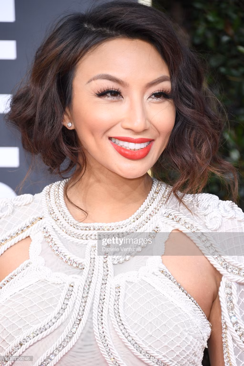 Jennie Mai - nghệ sĩ trang điểm kiêm MC người mẫu gốc Việt nổi tiếng với show How Do I Look? - nổi bật trong bộ jumpsuit trắng đính cườm sáng tạo ở phần thân trên.