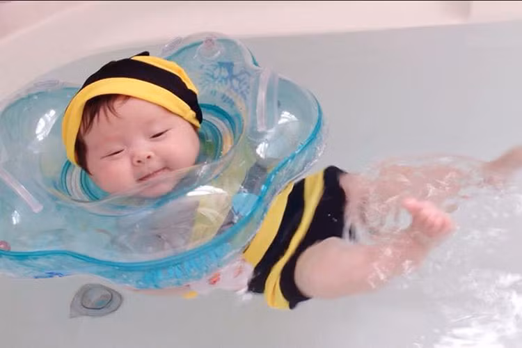 Con gái Elly Trần đáng yêu trong đồ bơi ong vàng khi tập bơi trong bồn tắm. 