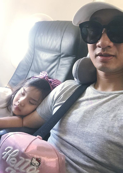 Bé Vi An tựa vào vai bố ngủ say sưa trên chuyến máy bay về thăm quê và ông bà nội. Nhiều người nhận xét cô nhóc sở hữu gương mặt có nhiều nét giống bố.