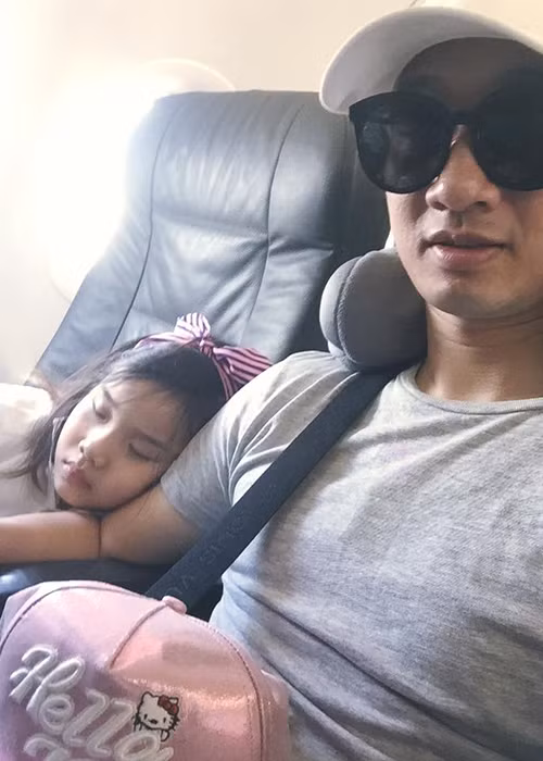 Bé Vi An tựa vào vai bố ngủ say sưa trên chuyến máy bay về thăm quê và ông bà nội. Nhiều người nhận xét cô nhóc sở hữu gương mặt có nhiều nét giống bố.