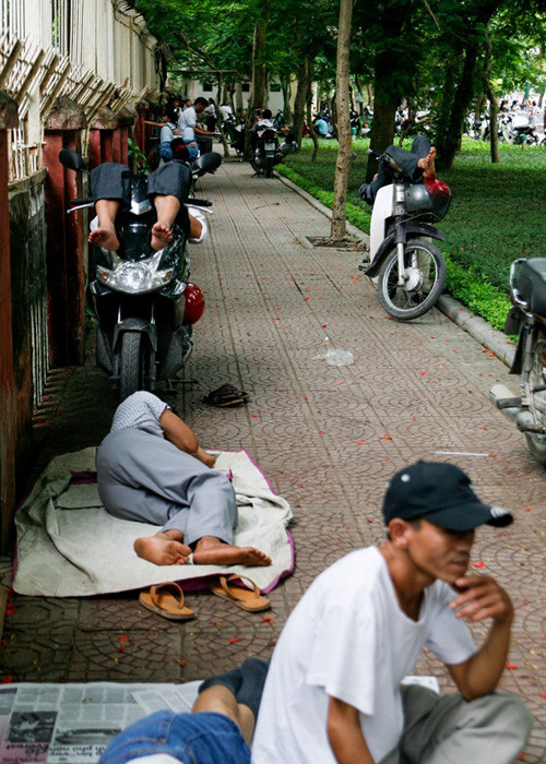 Nhiều người từ xa về, ngại vào quán giải khát dễ tốn kém nên thường tranh thủ nằm, ngồi ngay tại cổng trường chờ thí sinh kỳ thi THPT quốc gia. 