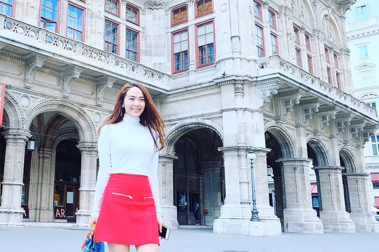 Trong thời tiết se lạnh của Vienna, cô chọn áo len cao cổ gam màu trắng kết hợp với chân váy cạp cao màu đỏ.