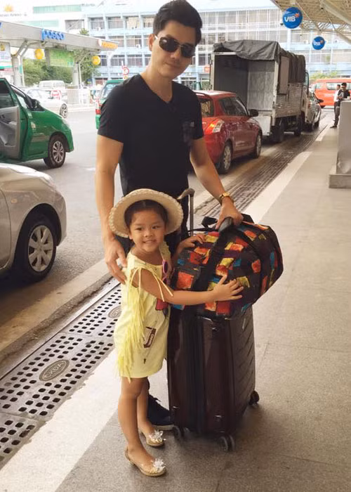 Bé Bell cùng bố Thành Được tạm biệt mẹ trước lên máy bay.