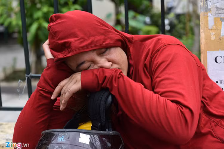 Một phụ nữ ngủ say ngay trên xe ở cổng trường Đại học Kinh tế Quốc dân, Hà Nội. 