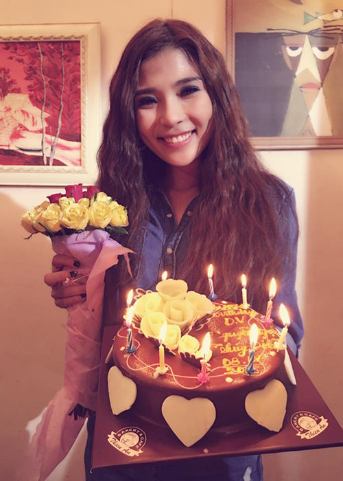 Nữ diễn viên hạnh phúc nhận bánh kem sinh nhật và bó hoa nhỏ từ ê-kíp phim.