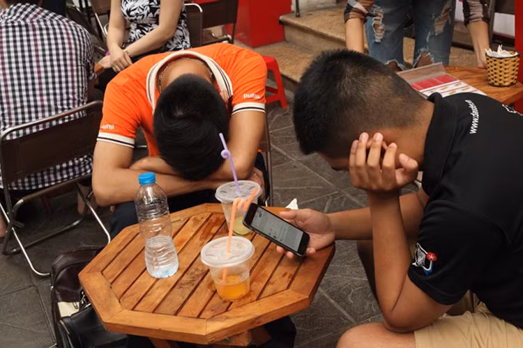 Hai anh đưa em trai đi thi ở trường THPT Phan Đình Phùng (Hà Nội). Những ngày này, các quán cà phê, trà đá quanh điểm thi hoạt động hết công suất. 