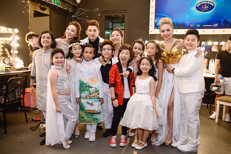 Nữ MC Vietnam Idol Kids chụp ảnh kỷ niệm cùng dàn ban giám khảo và các thí sinh của chương trình. 