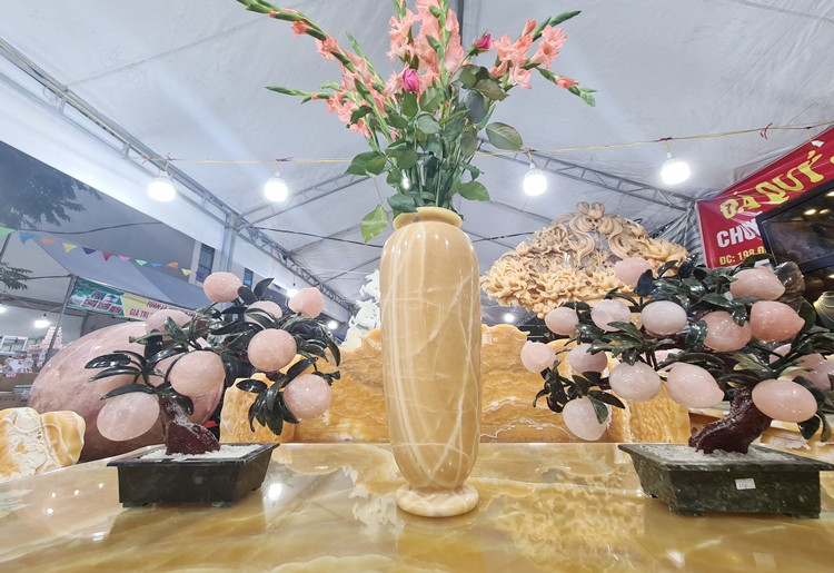 Để tăng thêm sự sang trọng và cuốn hút cho bộ bàn ghế, chủ gian hàng trưng bày thêm những bình hoa cũng được chế tác từ ngọc Hoàng Long. Hay những chậu cây cảnh làm từ đá quý khác.