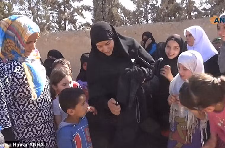 Một cô gái dùng bật lửa đốt khăn trùm đầu trên phố.