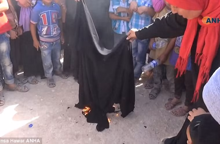 Mọi người tập trung xem cô gái đốt khăn trùm đầu.