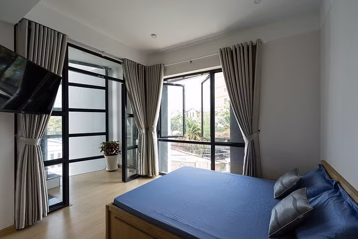 Không gian phòng ngủ đơn giản, màu sắc trung tính, sử dụng cửa kính nên trong phòng luôn ngập tràn ánh sáng.