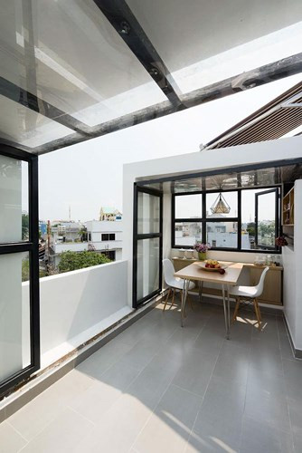 Diện tích còn lại làm phòng khách, như một không gian mở không mái. Phần mái sử dụng kính chữ L bằng thủy tinh.