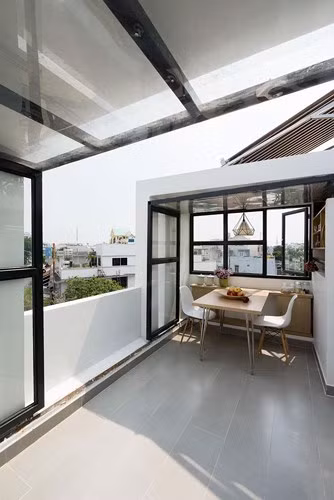 Diện tích còn lại làm phòng khách, như một không gian mở không mái. Phần mái sử dụng kính chữ L bằng thủy tinh.