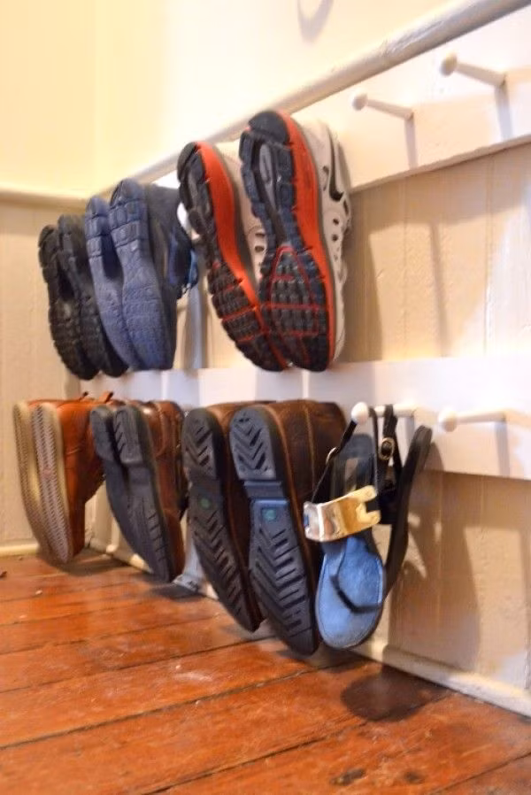 Chỉ với những chiếc móc được sử dụng để treo quần áo nhưng lại gắn lên tường sát với sàn nhà để làm chức năng treo giày dép. Những đôi giày được treo ngăn nắp trên móc vừa giúp bạn dễ dàng tìm giày khi cần và cũng giúp lối vào được thoáng đẹp, gọn gàng hơn.