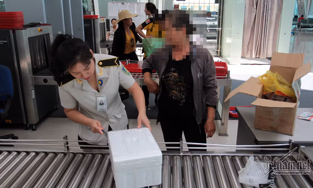 Nhân viên an ninh Phan Thị Yến mở thùng xốp nghi ngờ có nhiều đồ dùng không an toàn. Sau khi mở ra, trong đó là bánh mướt tráng và mấy hũ cà hành khách mang vào TP.HCM làm quà.
