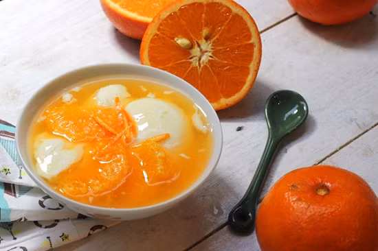 - Cuối cùng bạn cho tào phớ vào nồi nước cam rồi tắt bếp. Khi cho tào phớ vào bạn không khuấy nhé, để tránh làm tào phỡ bị vỡ vụn ra. - Giờ thì múc chè ra từng bát, rắc thêm một chút vụn vỏ cam lên trên cùng là có thể thưởng thức rồi. Nếu muốn ăn lạnh thì bạn để chè vào ngăn mát tủ lạnh hoặc cho thêm vài viên đá vào là được nhé.