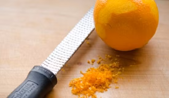 Cách làm món chè tào phớ: - Quả cam thứ nhất bạn bào lớp vỏ ngoài của cam thành các vụn nhỏ.