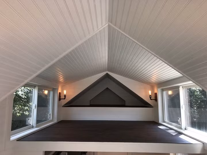 Phòng ngủ không cao nhưng thoáng mát, có cửa kính nhìn ra bên ngoài.