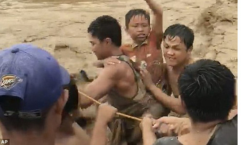 Người dân Philippines gồng mình trong cơn lũ. Ảnh: AP